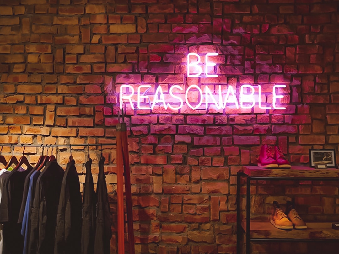 Enseigne néon LED rose dans une boutique de vêtements avec portant de mode