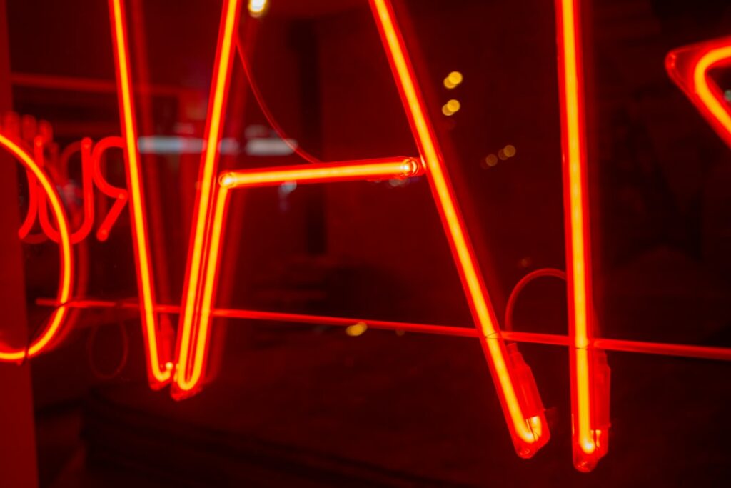 Gros plan sur un tube néon LED rouge incandescent — illustration de la qualité d'émission lumineuse et de l'étanchéité IP d'une enseigne extérieure