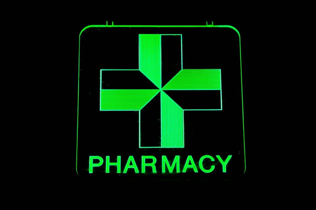 Panneau de croix verte lumineuse de pharmacie en LED, rendu de couleur Pantone 354 U sur fond noir