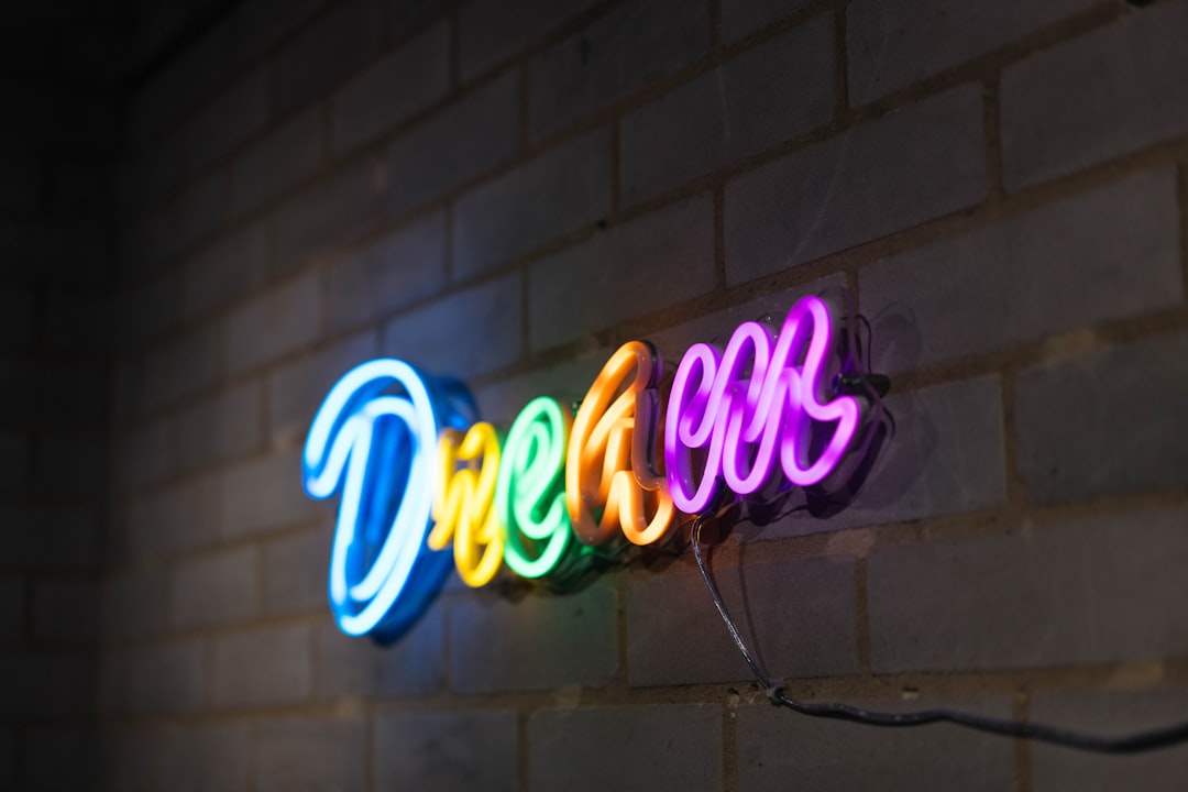 Néon LED personnalisé multicolore avec le mot Dream sur un mur en briques