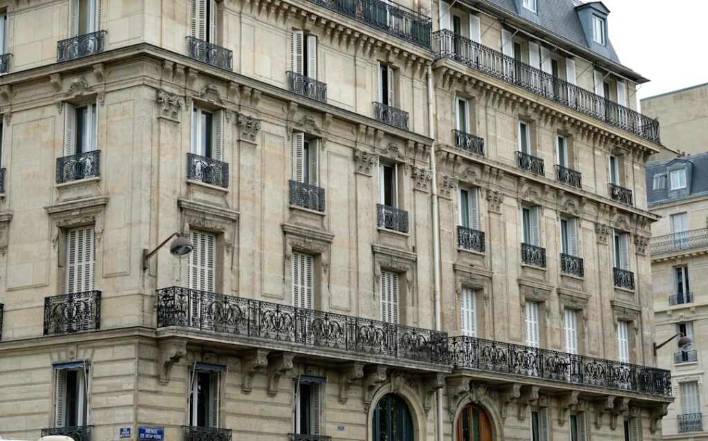 Façade d'immeuble haussmannien à Paris avec pierre de taille et balcons en fer forgé — type de support pour enseignes lumineuses extérieures